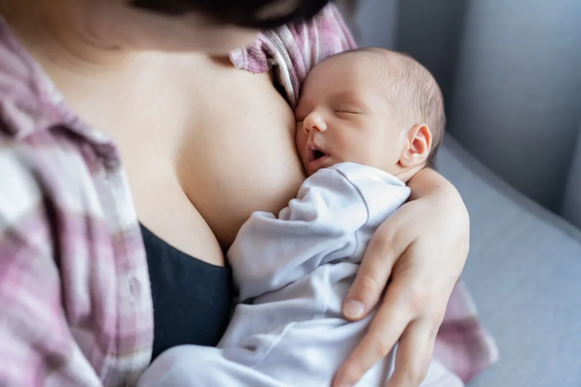 Nouveau-né qui dort paisiblement sur maman après la tétée.