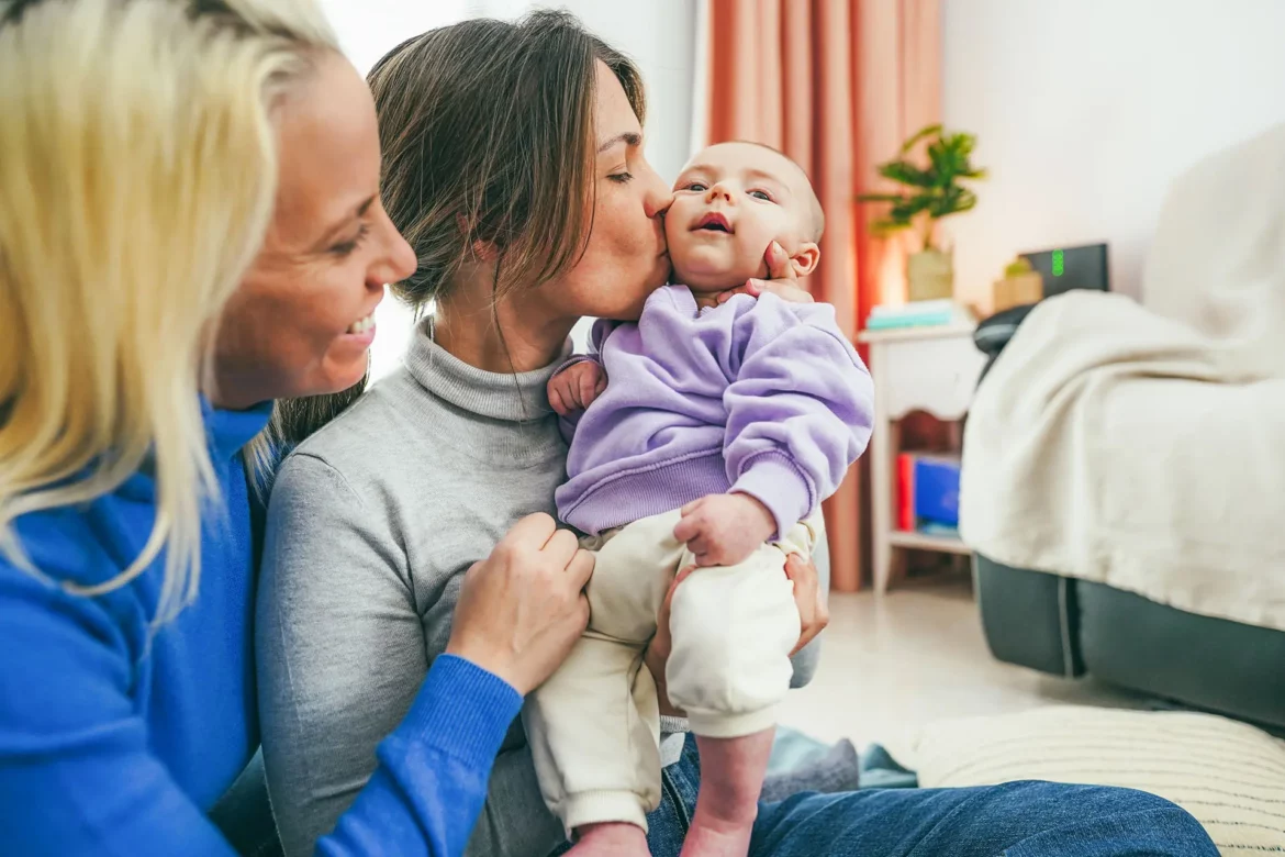 Un couple de femme regardent leur bébé
