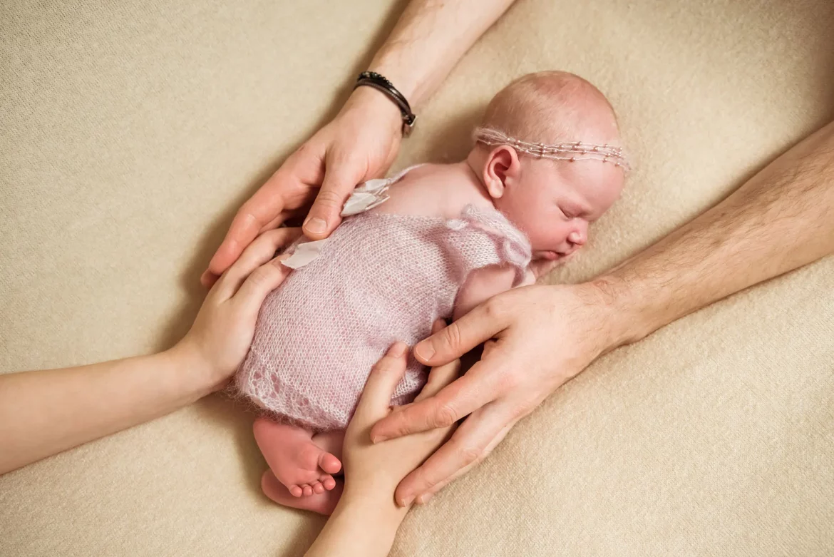 Une toute petite fille qui est entourée de ses deux parents