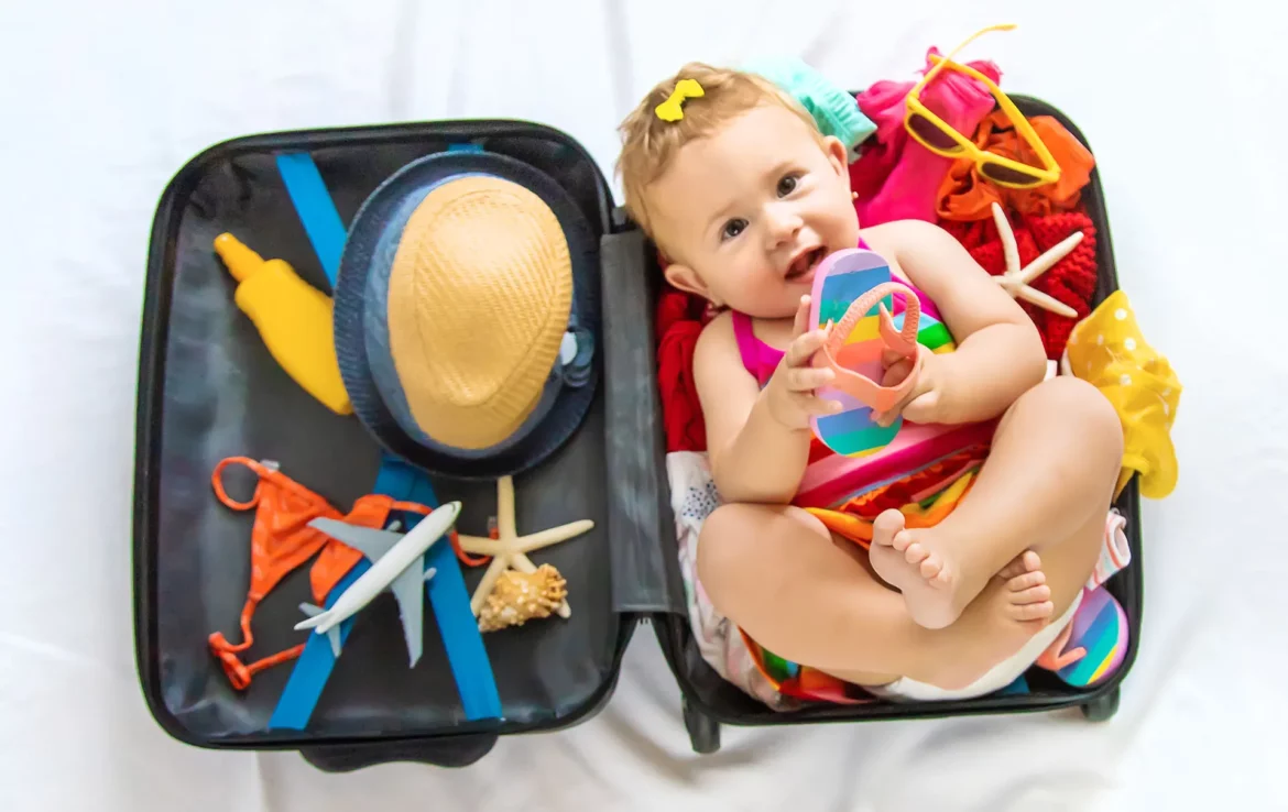 Un bébé se trouve dans une valise, comme près à partir en vacances