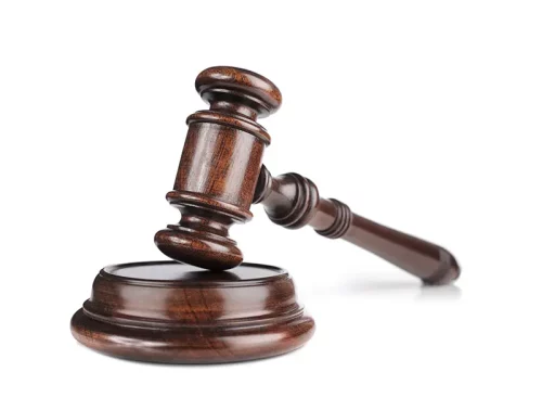 Un marteau de juge en bois posé sur son socle, symbole de la justice, des décisions juridiques et des droits civiques