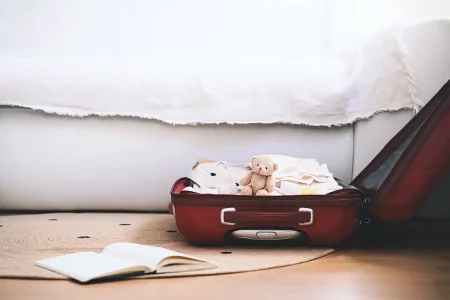 Valise maternité Valise ouverte prête pour la maternité avec vêtements de bébé et peluche soigneusement rangés